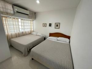 a bedroom with a bed and two lamps at Apartamentos En Edificio Portofino in Cartagena de Indias