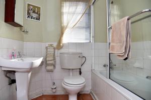 a bathroom with a toilet and a sink and a shower at Villa Moria Peace Cottage in Dullstroom +23 photos