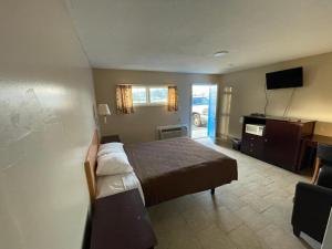 Habitación de hotel con cama y TV en Budget Inn Decatur Priceville, en Decatur