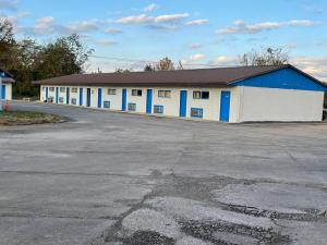 un gran edificio blanco y azul con aparcamiento en Budget Inn Decatur Priceville, en Decatur