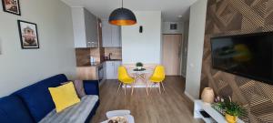 - un salon avec un canapé et une table avec des chaises jaunes dans l'établissement APARTAMENT SORENTO 28, à Gorzów Wielkopolski