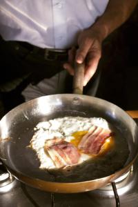 a person is cooking food in a pan at Costa Dorada in Cala Gonone