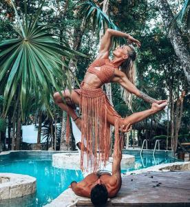 a woman standing on top of a man next to a pool at Bufo Alvarius in Tulum