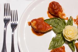 a plate of food with chicken and greens on it at Costa Dorada in Cala Gonone