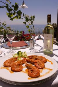 a plate of food on a table with a bottle of wine at Costa Dorada in Cala Gonone
