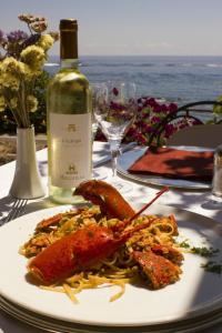 a plate of food on a table with a bottle of wine at Costa Dorada in Cala Gonone