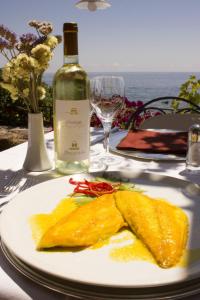 a plate of food on a table with a bottle of wine at Costa Dorada in Cala Gonone