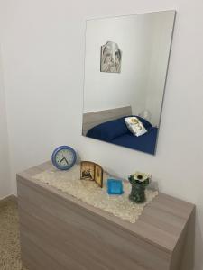 a mirror on top of a dresser in a bedroom at Marsala beddra lu suli, lu Mari e lu ventu in Marsala