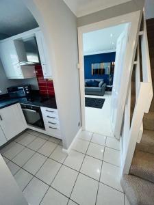 a kitchen with a staircase leading to a living room at Modern Home, Close to the City Centre with Parking in Birmingham