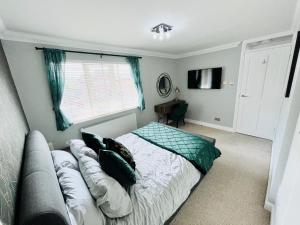 a bedroom with a bed and a couch and a window at Modern Home, Close to the City Centre with Parking in Birmingham