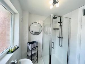 a bathroom with a shower and a toilet and a mirror at Modern Home, Close to the City Centre with Parking in Birmingham