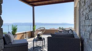 a patio with couches and a view of the ocean at Apartments King and Queen in Povile