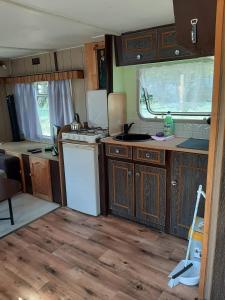 an rv kitchen with wooden cabinets and a white refrigerator at Holenderka Artur in Stegers