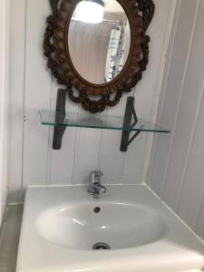 een wastafel in de badkamer met een spiegel aan de muur bij Holenderka Artur in Stegers