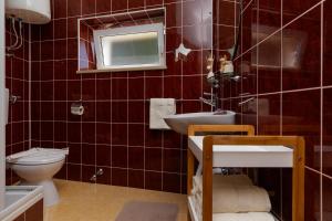 baño de azulejos rojos con aseo y lavamanos en Panorama Apartment, en Bol