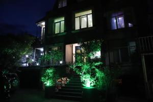 a house with green lights on the stairs at night at Hotel Black Sea House in Batumi