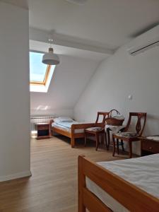 Habitación con 2 camas, sillas y ventana en Kuća za odmor Vallirea, en Kaptol