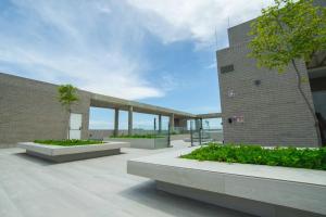 バランキージャにあるSuite de lujo Distrito 90の茂みと木々が茂る中庭のある建物