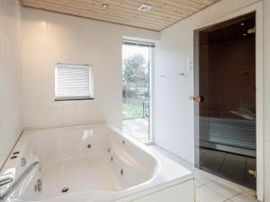 a large white bath tub in a bathroom with a window at 10 person holiday home in V ggerl se in Marielyst