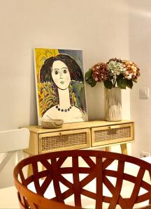 uma pintura de uma mulher sobre uma mesa com uma cadeira em Precioso piso en el centro neurálgico de Olot em Olot