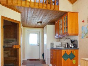 cocina con armarios de madera y techo de madera en Holiday home in Vreta en Borensberg