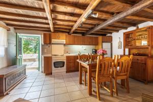 a kitchen with a table and chairs and a stove at La Belle Merle in Panormos Skopelos
