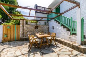 a patio with a wooden table and chairs at La Belle Merle in Panormos Skopelos