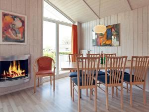 a dining room with a fireplace and a table and chairs at 4 person holiday home in GROEMITZ in Grömitz