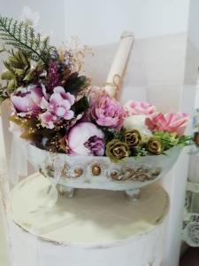 a bouquet of flowers in a bowl on a table at Guest House Orchidea in Pomorie