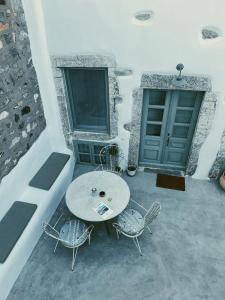 a patio with a table and chairs and two doors at Latmos 1860 in Skala