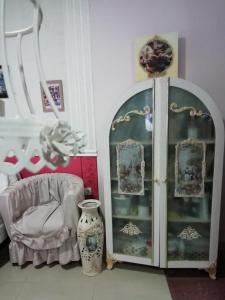 ポモリエにあるGuest House Orchideaの椅子、キャビネット、花瓶が備わる客室です。