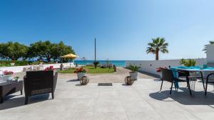 patio ze stołem i krzesłami oraz oceanem w obiekcie Vrachos holiday home w Alikanás