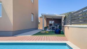 a backyard with a swimming pool and a house at Apartments King and Queen in Povile