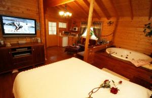 a bedroom with a bed and a tv and a tub at Spa Chalets In Olive Grove in Eli Ad