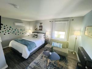 1 dormitorio con 1 cama y 1 sofá en 1915 Beach Club, en Daytona Beach