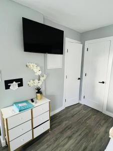 a bedroom with a dresser and a flat screen tv on the wall at 1915 Beach Club in Daytona Beach