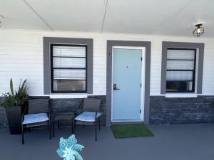 a house with a porch with chairs and a door at 1915 Beach Club in Daytona Beach