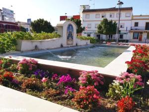 een fontein midden in een tuin met bloemen bij El Faisan C&R Hotel in Arcos de la Frontera