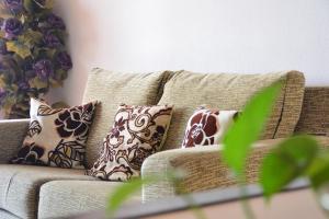 eine Couch mit Kissen darauf in einem Wohnzimmer in der Unterkunft Apartamentos Be Suites Mar de Azahar in Oropesa del Mar