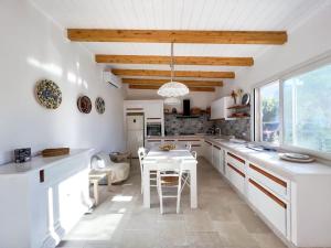 a kitchen with white cabinets and a white table and chairs at Casa Comada - Torre Lapillo in Torre Lapillo +21 photos