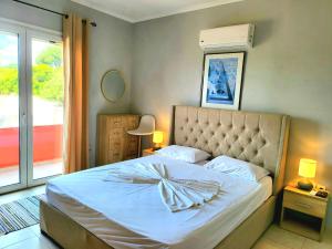 sypialnia z łóżkiem z łukiem w obiekcie Helios Apartments - Beach of Lachania Rhodes w mieście Lakhania