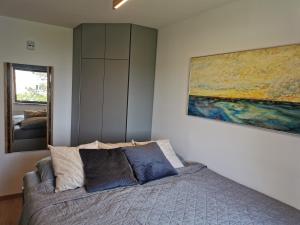 a bedroom with a bed and a painting on the wall at DOM LORON in Poreč