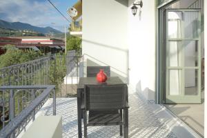 un jarrón rojo sentado en una mesa en un balcón en Isavella's apartments under the castle en Kalamata