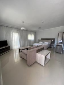 a living room with a couch and tables and a television at Colibri in Kallithea Halkidikis