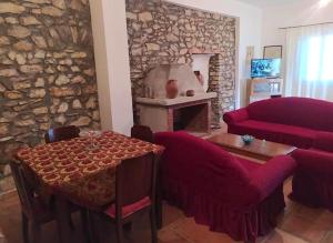 a living room with a table and a red couch at Antonia's Rustic Retreat in Dhórion