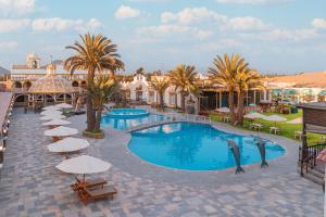 a large swimming pool with umbrellas and a resort at Macacona Hacienda Hotel in Ica