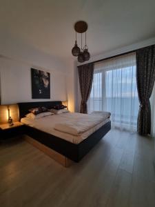 een slaapkamer met een groot bed en een groot raam bij Deluxe Lake View in Mamaia