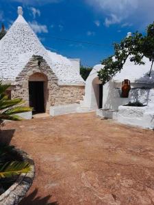 a white building with a pot sitting on top of it at Trullo Antelmi in Ceglie Messapica