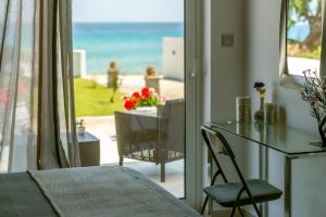 a room with a balcony with a table and a view of the ocean at Vrachos holiday home in Alikanas