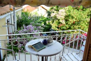 a table with a book on a balcony with flowers at Fiori Studios Fiscardo in Fiskardho